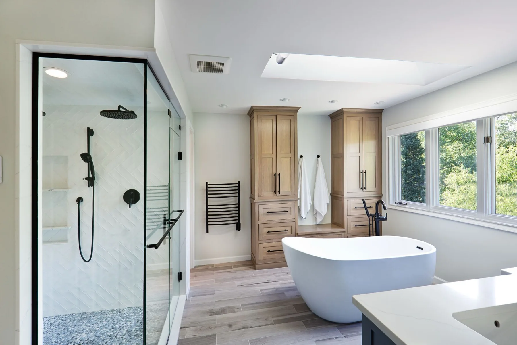 A remodeled bathroom with a freestanding tub and glass shower